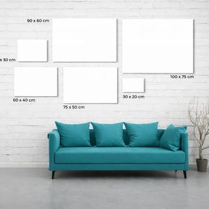 May include: A teal sofa with five matching cushions positioned below a gallery wall arrangement of six blank white rectangular canvases. The canvases are labeled with dimensions: 40x30 cm, 90x60 cm, 100x75 cm, 60x40 cm, 75x50 cm, and 30x20 cm.