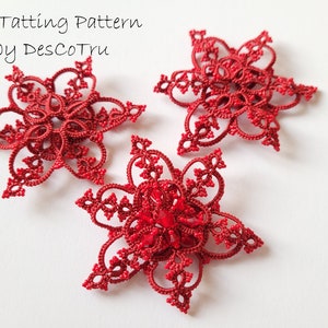 May include: Three red crocheted snowflakes, each with a delicate, intricate design. The snowflakes are on a white background.