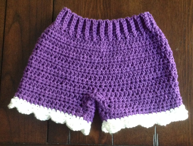 May include: Purple crochet shorts with a white crocheted lace trim.