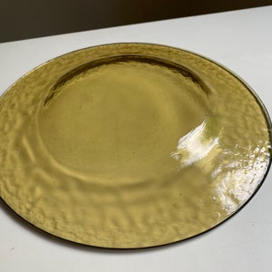 May include: A large, round, amber-colored glass plate with a textured surface.