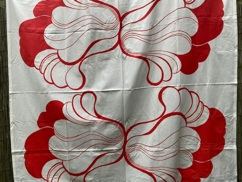 May include: White fabric with a repeating pattern of red, organic shapes. The shapes are reminiscent of stylized flowers or leaves.