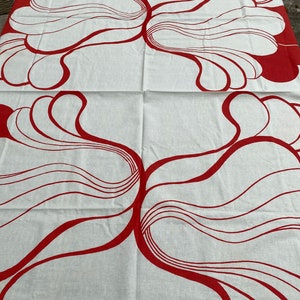 May include: White fabric with a red abstract design of overlapping curved lines and shapes. The design is symmetrical and appears twice on the fabric.