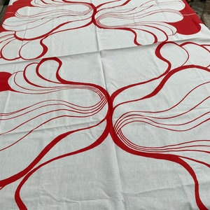 May include: White tablecloth with a red abstract design of swirling lines and shapes.