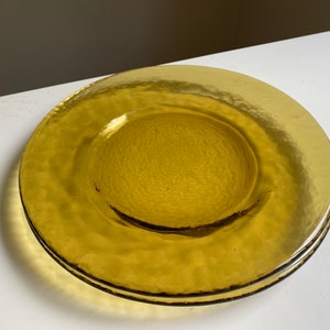 May include: A set of two amber glass dinner plates with a textured surface.