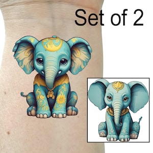 May include: Set of two temporary tattoos featuring a blue elephant with yellow and gold accents. The elephant is sitting with its legs crossed and has a decorative design on its body.