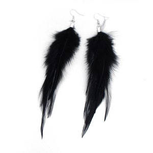 May include: A pair of long black feather earrings with silver hooks.
