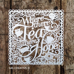 May include: White paper cut-out art with a decorative border and floral designs. The text reads "Where there's Tea there's Hope".