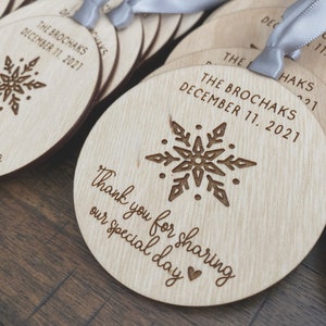 May include: Wooden round ornaments with a snowflake design and the text "Thank you for sharing our special day" and "The Brochaks December 11, 2021".