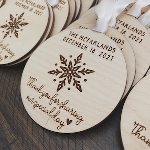 May include: Round wooden ornaments featuring a snowflake design and the text "Thank you for sharing our special day" and "The McFarlands December 18, 2021".