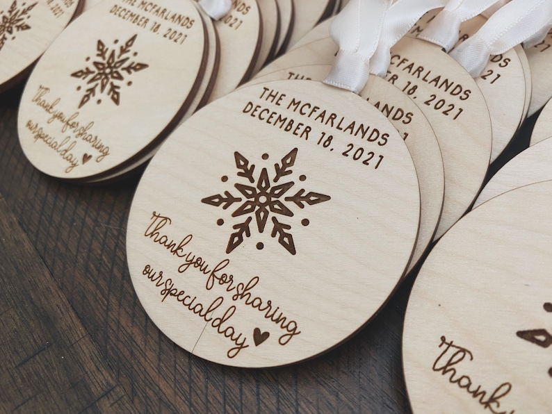May include: Round wooden ornaments featuring a snowflake design and the text "Thank you for sharing our special day" and "The McFarlands December 18, 2021".