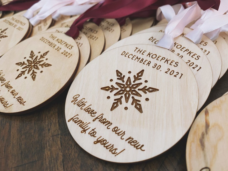 May include: A set of round wooden ornaments with a snowflake design and the text "The Koepkes December 30, 2021" and "With love from our new family to yours!"