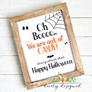 May include: A framed Halloween sign with a rustic wooden frame. The white sign features a black spiderweb, ghost illustrations, and the text "Oh Boooo... We are out of CANDY!" in black and orange. The sign also says "Sorry about that Happy Halloween."