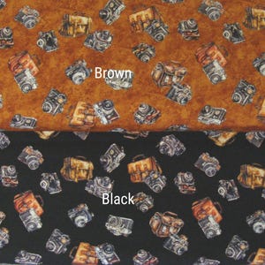 May include: Fabric with a repeating pattern of vintage cameras and camera bags. The top half is brown, and the bottom half is black. The word "Brown" is written on the brown fabric, and the word "Black" is written on the black fabric.