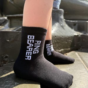 May include: Black socks with the words "Ring Bearer" written in white on them.