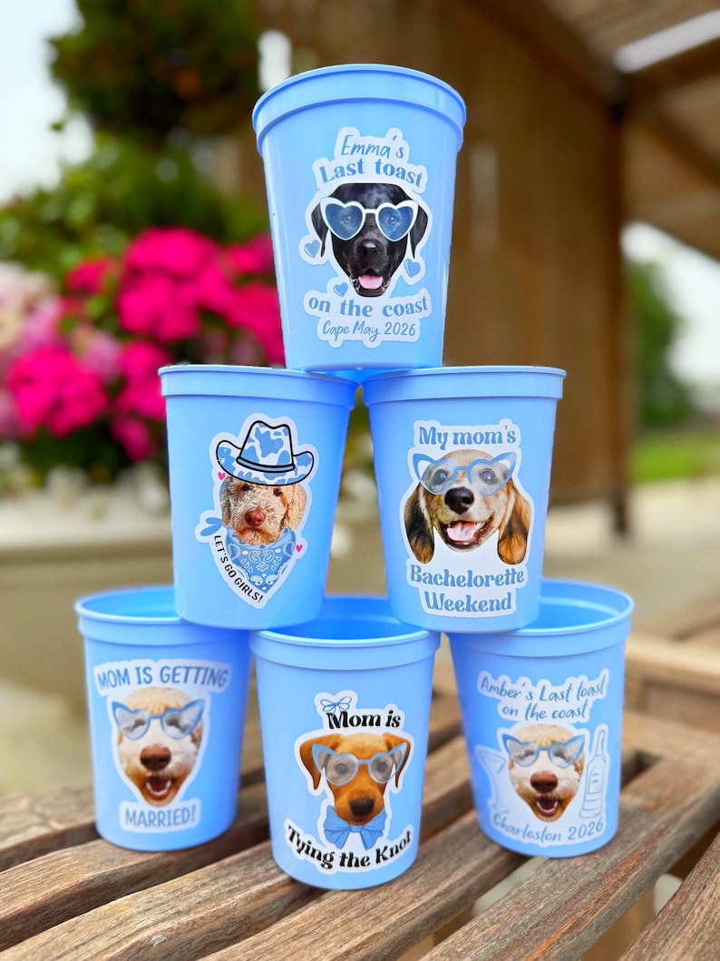 Peut inclure: Une pile de six gobelets de stade en plastique bleu clair, chacun orn&eacute; d'un graphique personnalis&eacute; repr&eacute;sentant un chien portant des lunettes. Le texte inclut des phrases comme Emma's Last Toast, My mom's Bachelorette Weekend et Mom is tying the knot.