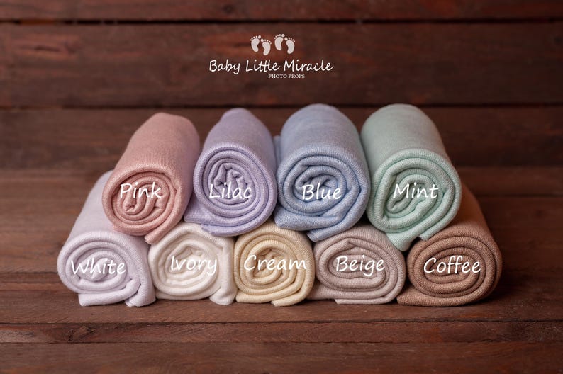 K&ouml;nnte beinhalten: Gerollte Baby-Foto-Requisiten in verschiedenen Farben wie Rosa, Lila, Blau und Mint, mit Etiketten f&uuml;r die Farben: Wei&szlig;, Elfenbein, Creme, Beige und Kaffee. Der Text "Baby Little Miracle PHOTO PROPS" ist ebenfalls vorhanden.