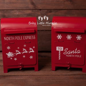 Peut inclure: Deux boîtes aux lettres rouges en métal avec lettrage et graphiques blancs. L'une dit "North Pole Express" avec un traîneau et des rennes. L'autre dit "To Santa North Pole" avec des flocons de neige. Les boîtes aux lettres sont des accessoires.