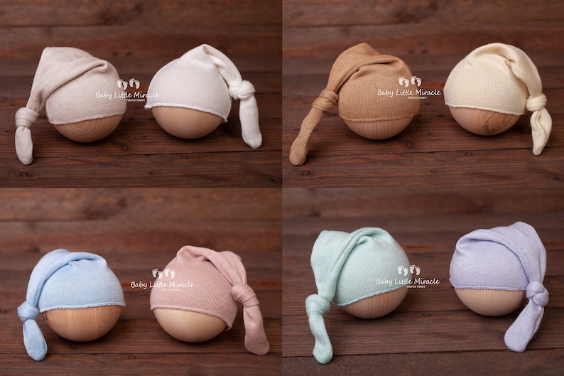 K&ouml;nnte beinhalten: Sechs Neugeborenen-M&uuml;tzen in verschiedenen Farben: Beige, Wei&szlig;, Hellbraun, Creme, Hellblau, Rosa, Mintgr&uuml;n und Lavendel. Jede M&uuml;tze ist am Ende geknotet und sitzt auf einem Holz-Requisit.