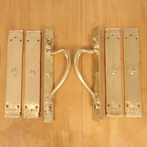 Puede incluir: Conjunto de seis tiradores de puerta de latón con un diseño floral decorativo. Los tiradores tienen forma de corazón y un estilo tradicional.