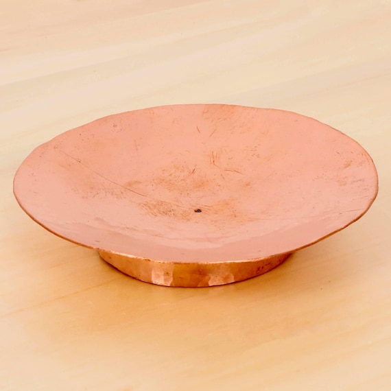 A hand-hammered copper dish with real visible craftsmanship — the beaten texture and warm patina make it look like it came from an artisan market abroad.
