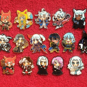 May include: A collection of 15 colorful enamel pins featuring anime-style characters. The pins are all different designs and feature a variety of colors, including blue, red, yellow, green, and black.