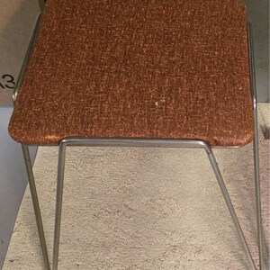 Difícil de encontrar, par de taburetes apilables, 100% vintage, totalmente originales, de estilo MCM, con patas estilizadas en forma de horquilla y asientos acolchados originales.