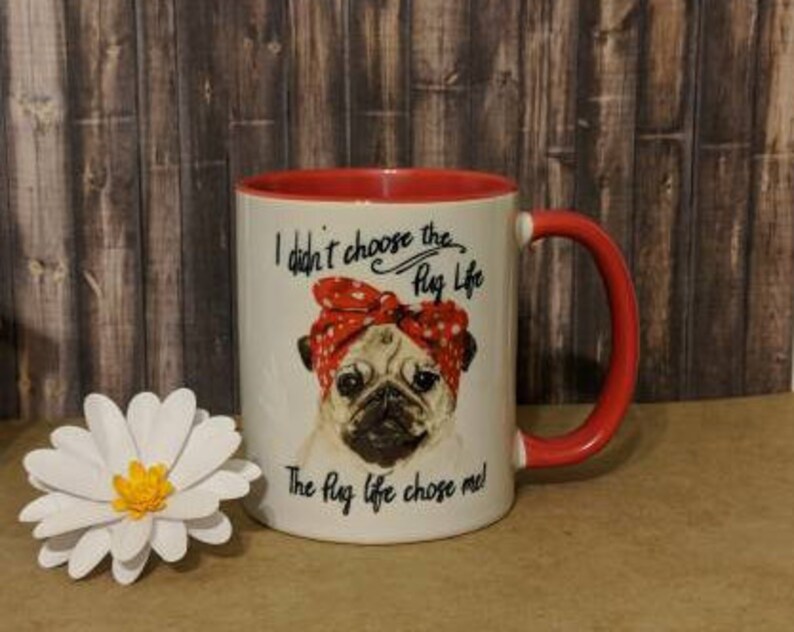 Peut inclure: Mug en c&eacute;ramique blanche avec int&eacute;rieur et anse rouges. Le mug repr&eacute;sente un carlin portant un bandana rouge &agrave; pois, avec le texte "I didn't choose the Pug Life. The Pug life chose me !" Une marguerite en papier blanc est &agrave; gauche.
