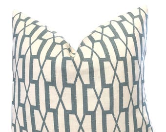 May include: A white pillow with a geometric pattern in a light blue color. The pattern is made up of repeating shapes that resemble hexagons.