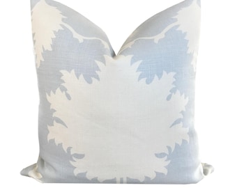 May include: A light blue throw pillow with a white floral pattern. The pillow is made of a soft, textured fabric.