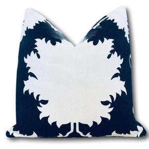 May include: Square throw pillow with a white and navy blue leaf pattern. The pillow features a large white leaf design against a navy blue background. The pillow is made of a textured fabric and is suitable for home decor.
