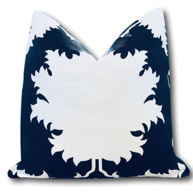 May include: Square throw pillow with a white and navy blue leaf pattern. The pillow features a large white leaf design against a navy blue background. The pillow is made of a textured fabric and is suitable for home decor.