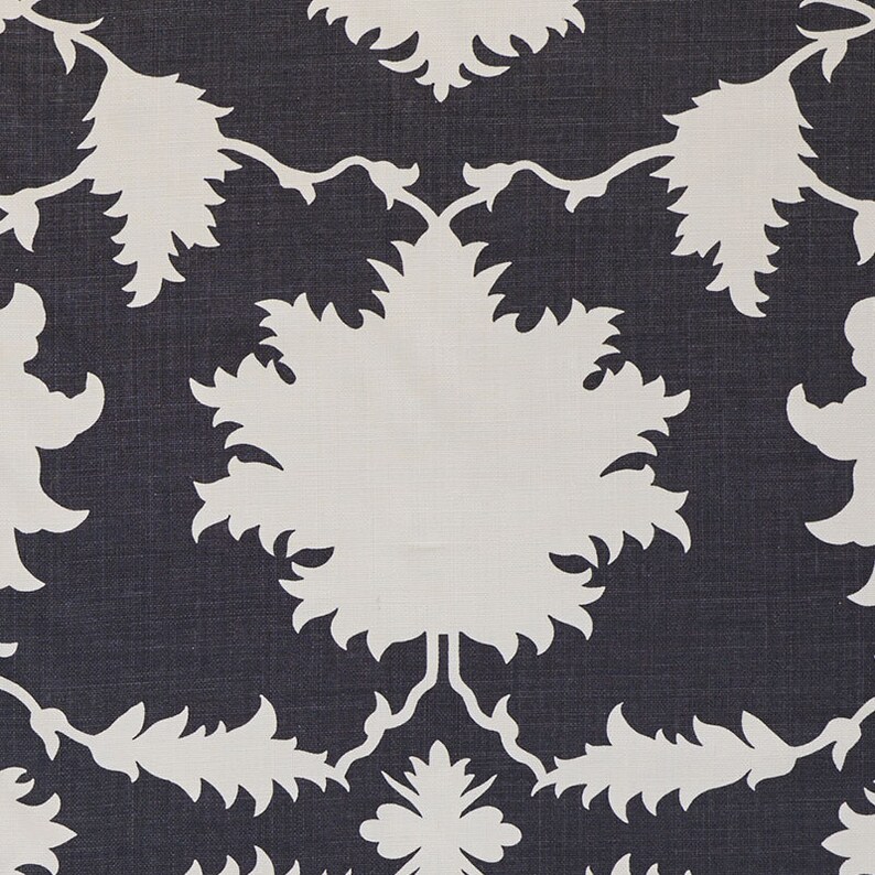 K&ouml;nnte beinhalten: Nahaufnahme eines Stoffes mit einem sich wiederholenden Muster. Das Muster zeigt gro&szlig;e, wei&szlig;e, stilisierte Blumen- und Blattformen vor einem dunkelblauen Hintergrund. Das Design ist symmetrisch und erzeugt eine visuell ansprechende Textur.