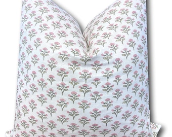 May include: A square decorative pillow with a white background and a repeating pattern of pink floral designs. The pillow has a soft, inviting appearance, perfect for adding a touch of elegance to any room. The floral pattern is detailed and adds visual interest.