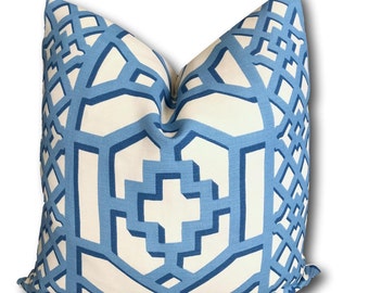 May include: A square decorative pillow with a geometric pattern in shades of blue and white. The design features interlocking shapes and lines, creating a modern and stylish look. The pillow is likely made of a soft fabric, perfect for adding a touch of elegance to any room.