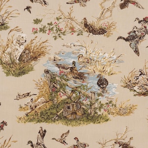 May include: Beige fabric with a detailed hunting scene. Ducks, a dog, and a hunting basket are depicted near a body of water. The design includes trees, grass, and other wildlife elements, creating a rustic, outdoorsy theme.