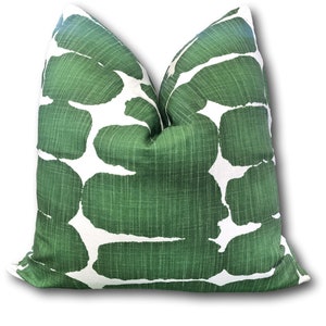 May include: A green and white patterned throw pillow with a geometric design. The pillow is made of a soft, textured fabric.