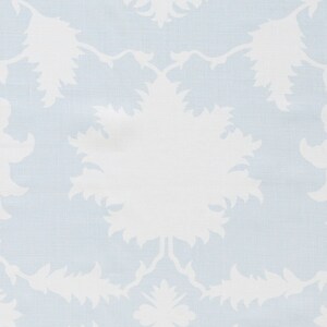 May include: A light blue fabric with a white floral pattern. The pattern is a repeating design of stylized flowers with a central circle.