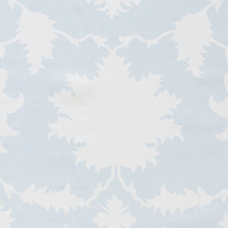 May include: A light blue fabric with a white floral pattern. The pattern is a repeating design of stylized flowers with a central circle.