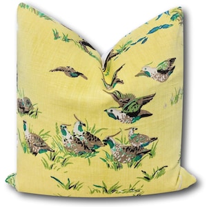 May include: Yellow throw pillow with a pattern of brown and green birds on a yellow background.