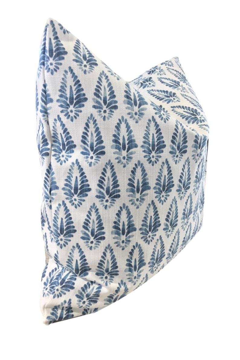 May include: A white pillow with a blue and white paisley pattern. The pillow is made of a soft, comfortable fabric and has a subtle sheen.