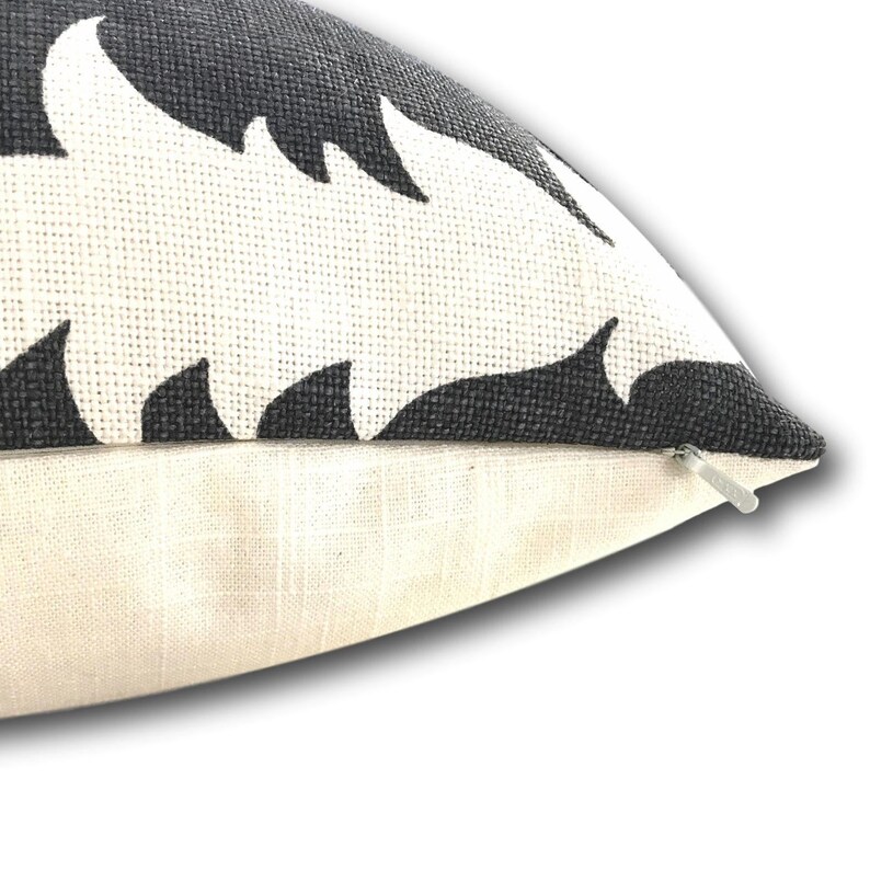 K&ouml;nnte beinhalten: Dekoratives Zierkissen mit einem schwarz-wei&szlig;en Bl&auml;ttermuster. Das Kissen hat eine strukturierte, gewebte Optik und einen verdeckten Rei&szlig;verschluss. Das Design zeigt ein sich wiederholendes Muster stilisierter Bl&auml;tter.