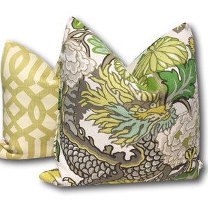 May include: Two decorative throw pillows with a green, yellow, and gray floral pattern featuring a dragon. One pillow has a geometric pattern in yellow and white.