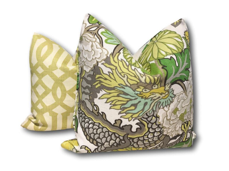 May include: Two decorative throw pillows with a green, yellow, and gray floral pattern featuring a dragon. One pillow has a geometric pattern in yellow and white.