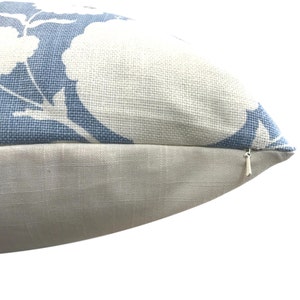 May include: A blue and white floral patterned pillow with a zipper closure.