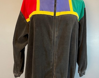 May include: A black velour zip-up jacket with a high collar. The jacket has colorful geometric panels in red, yellow, green, and purple.