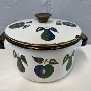 May include: White enamelware pot with a lid featuring a pear and apple design in green, blue, and gold. The pot has a brass knob on the lid.
