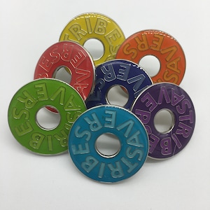 May include: Six colorful metal rings with the word "REVERSE" spelled out in different colors on each ring. The rings are arranged in a circle, with the word "REVERSE" facing outwards.