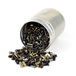 May include: A metal container tipped over, spilling a variety of screws onto a white surface. The screws are of different sizes and colors, including silver, gold, and black, suggesting a hardware or construction theme.