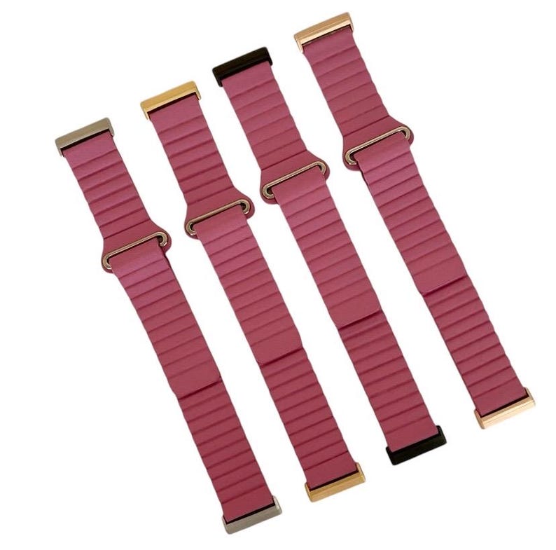 Peut inclure: Quatre bracelets de montre en silicone rose avec des fermoirs m&eacute;talliques de diff&eacute;rentes couleurs. Les bracelets ont une texture c&ocirc;tel&eacute;e et sont con&ccedil;us pour les montres intelligentes.