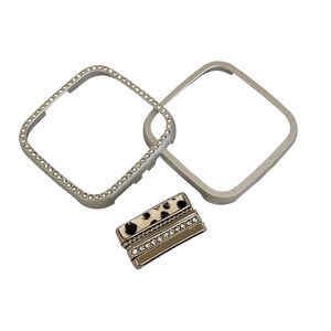 May include: A set of three silver-toned watch bands. One band is adorned with rhinestones, another is plain, and the third has a leopard print design with rhinestones.
